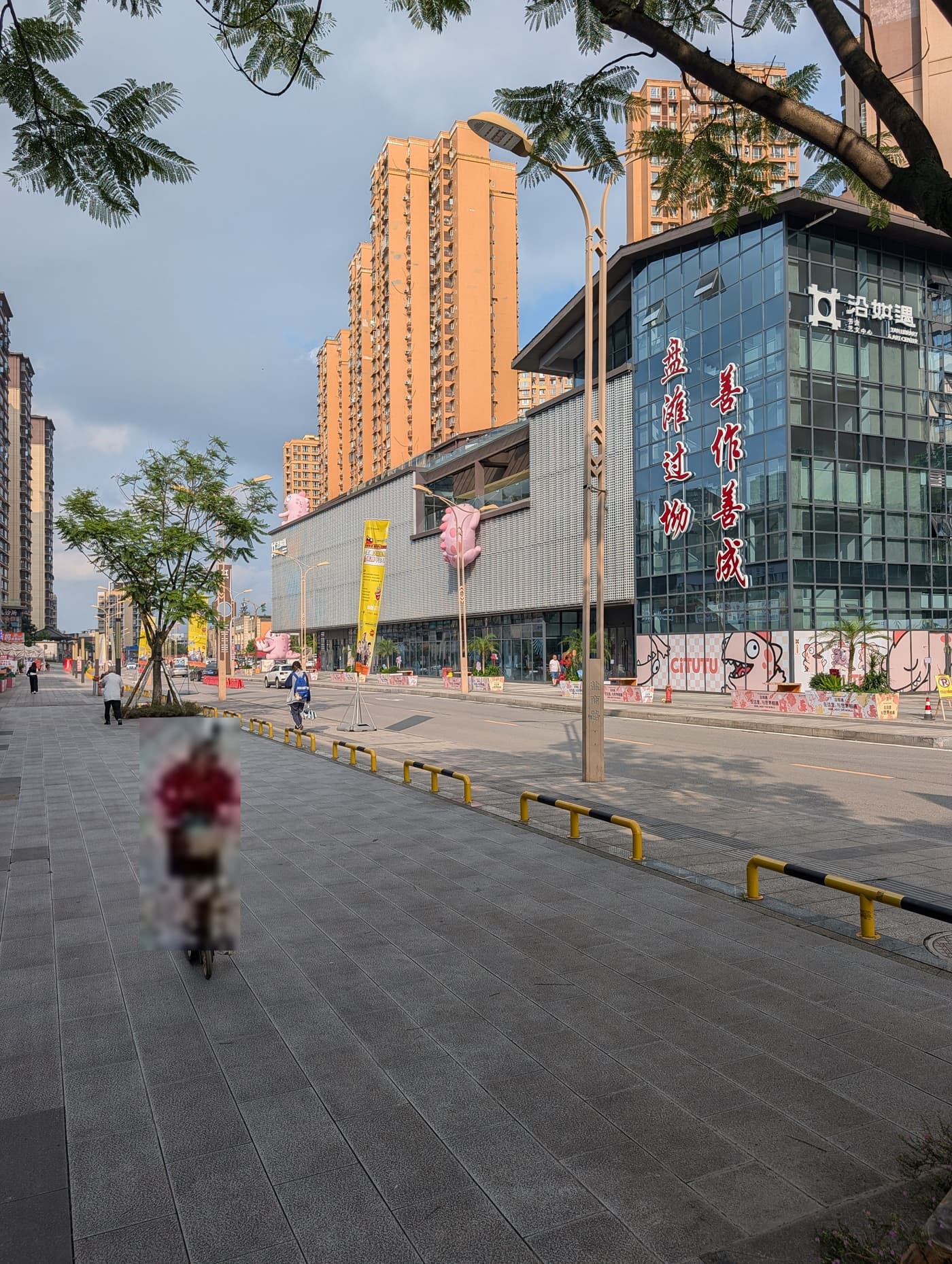 沿滩区沿如遇书舍艺文中心的临街一隅，广场上有人经过