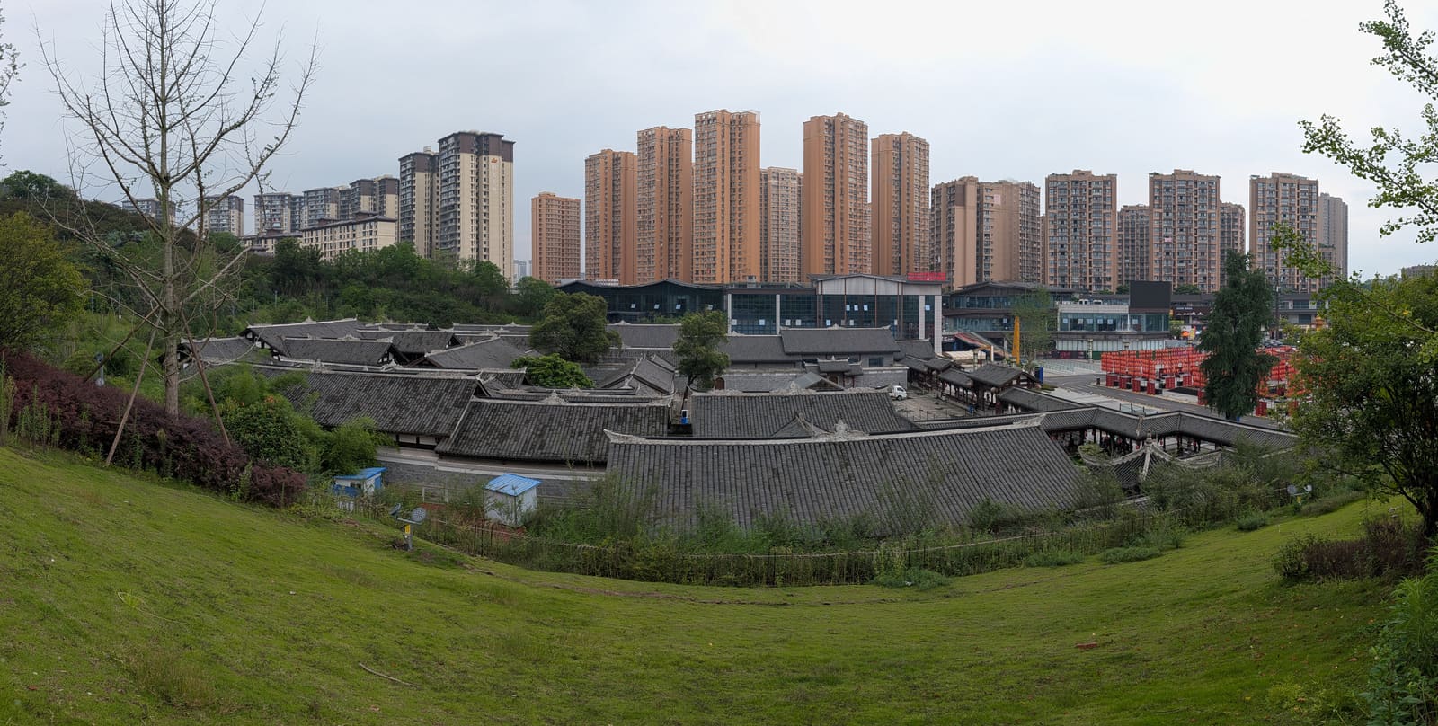 王家大院的灰瓦院落，背后是成排的高层住宅
